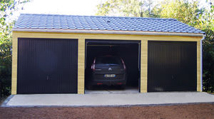 garage en béton aspect bois 2 pentes couverture tuiles entrée façade avec 3 portails basculants