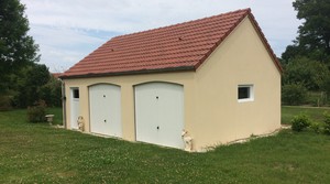 Garage double en béton avec 2 portes sectionnelles, une porte de service et un châssis. Toit deux pentes, couverture tuiles.