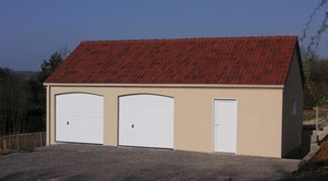 Double garage en béton avec 2 portes sectionnelles, une porte et un châssis PVC.