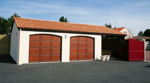 garage en béton 2 pentes couverture tuiles avec 2 portes sectionnelles et auvent accolé