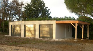 Triple garage en béton avec carport accolé. Couverture bacs acier.